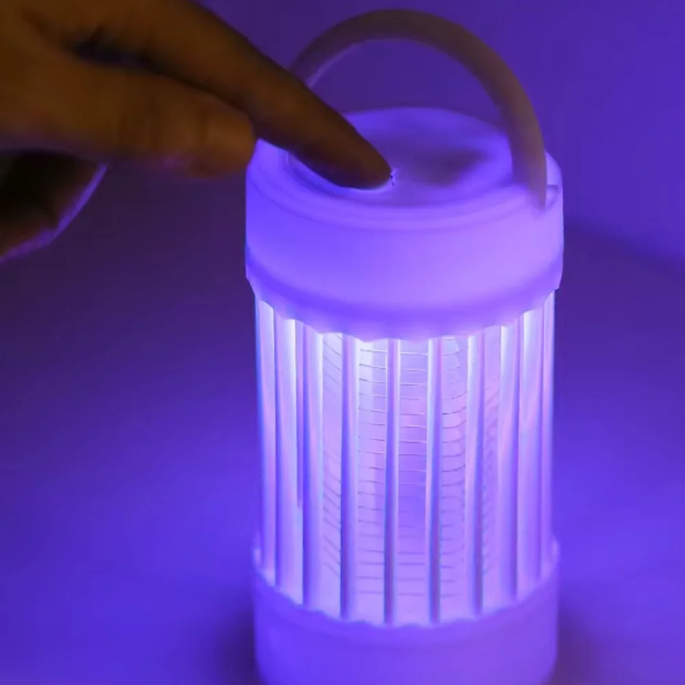 Lampe anti-moustique Luciolia allumée en mode veilleuse sur une table de terrasse, le soir