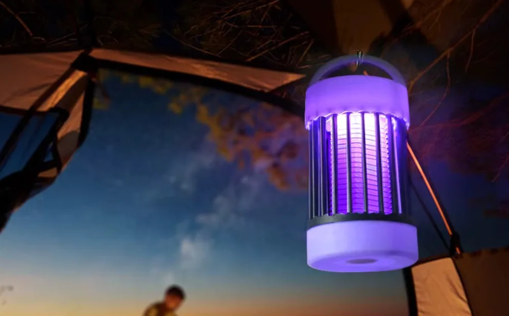 La lampe Luciolia suspendue à l’auvent d’une tente, en mode lumière chaude